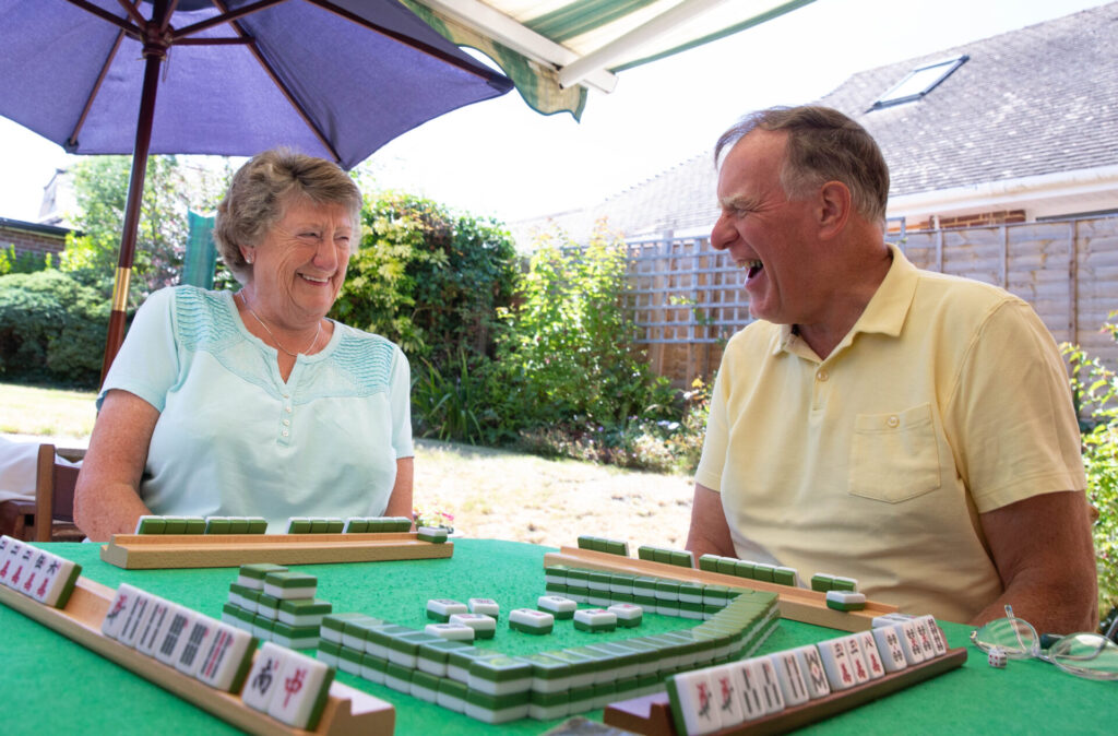 Two people at a table playing Mah-jong